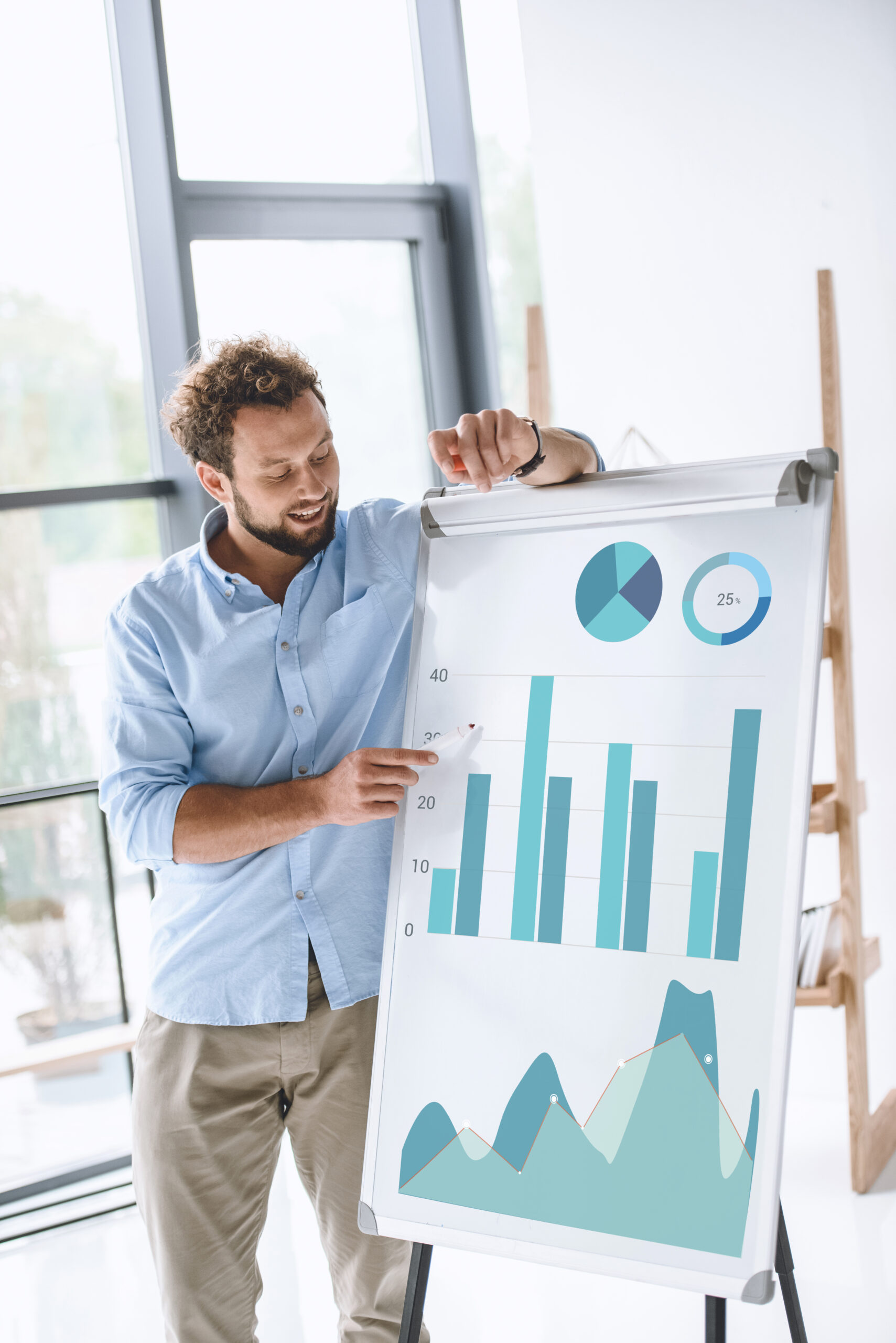 young businessman making presentation of diagrams at white board in office